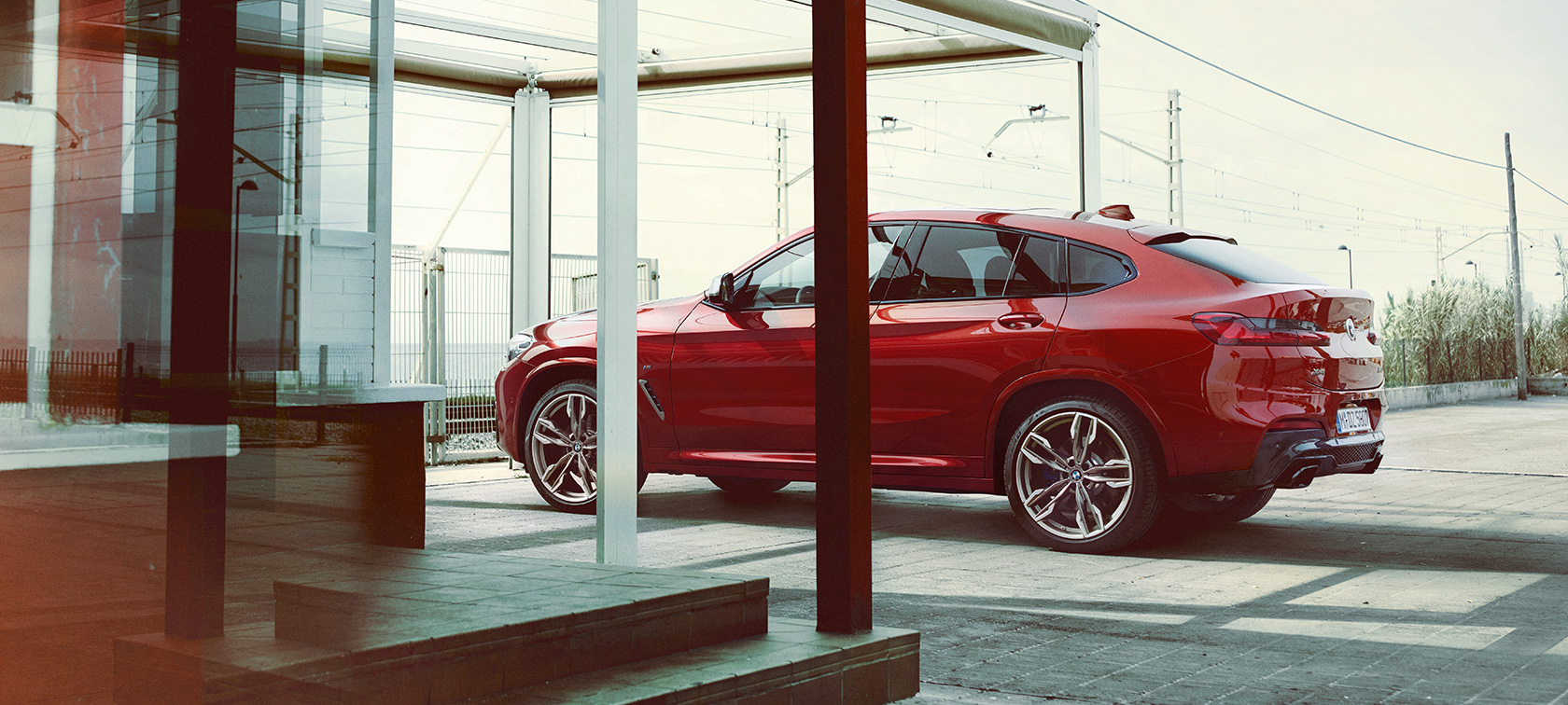 BMW X4 zijaanzicht BMW X4 M40i G02 2018 Flamencorot Brillanteffekt zijaanzicht geparkeerd