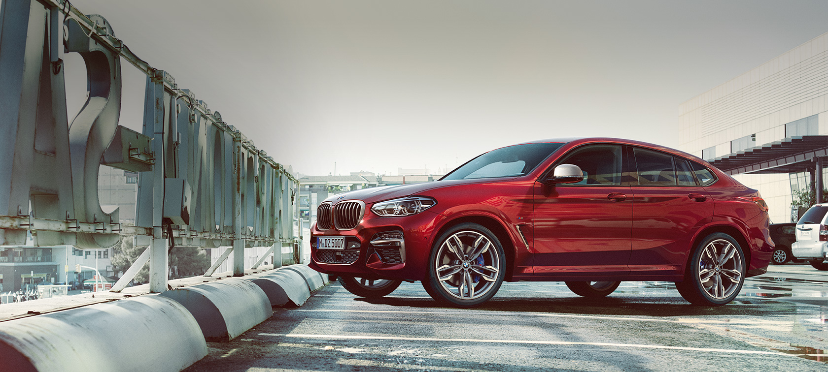 Zijaanzicht geparkeerde BMW X4 BMW X4 M40i G02 2018 Flamencorot Brillanteffekt zijaanzicht geparkeerd