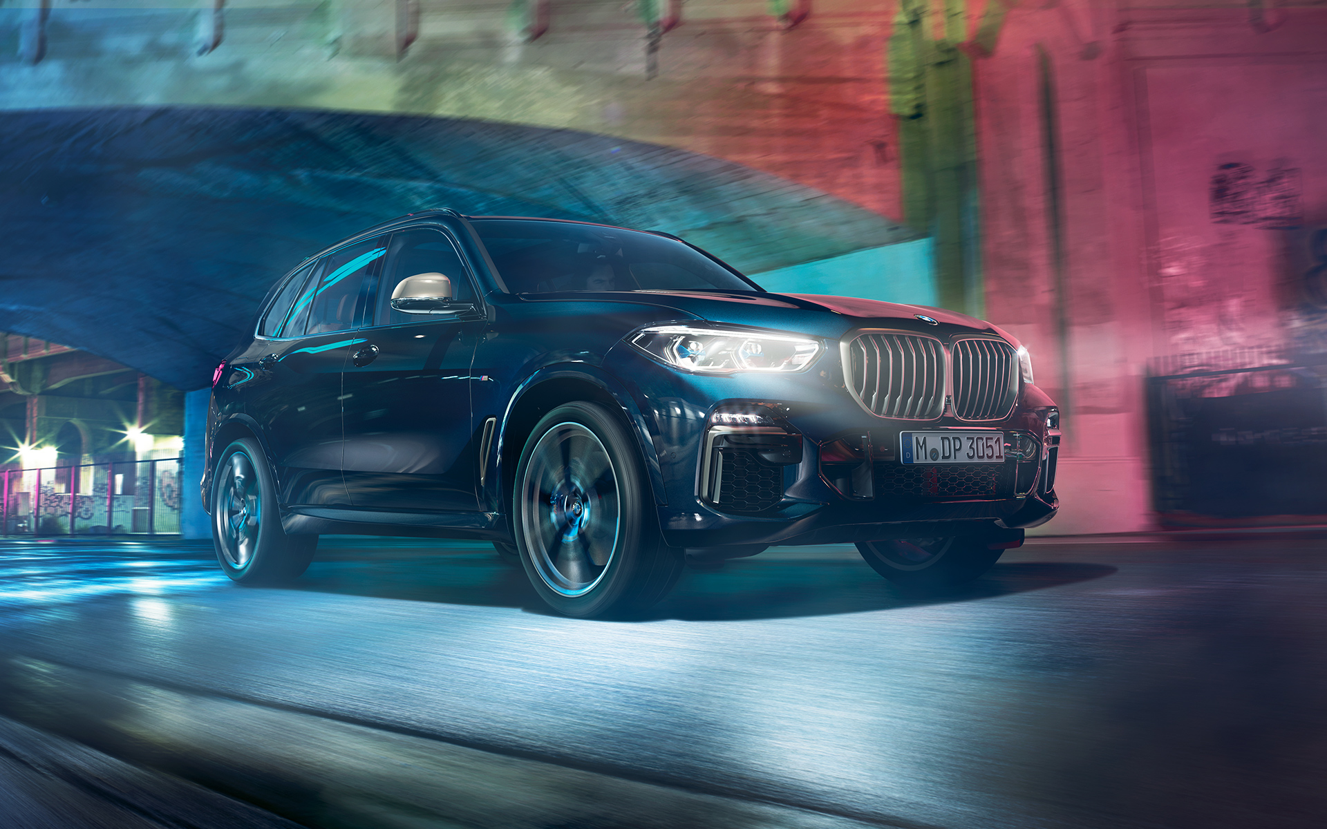 BMW X5 M50d in actie Rijdende BMW X5 M50d met op de achtergrond een nachtelijke skyline