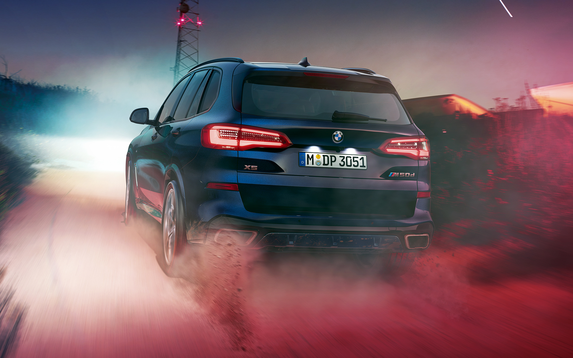 BMW X5 M50d achterzijde Achterzijde van de BMW X5 M50d met op de achtergrond een nachtelijke skyline