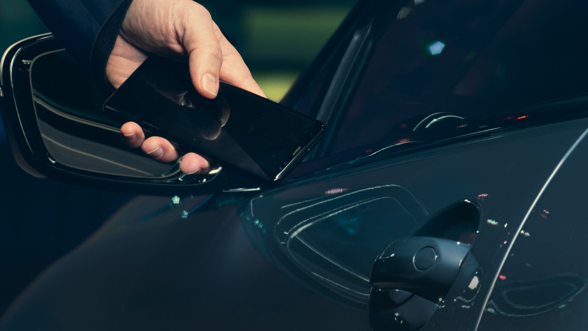 Digital Key Digital Key: man houdt zijn smartphone aan de buitenkant tegen het portier