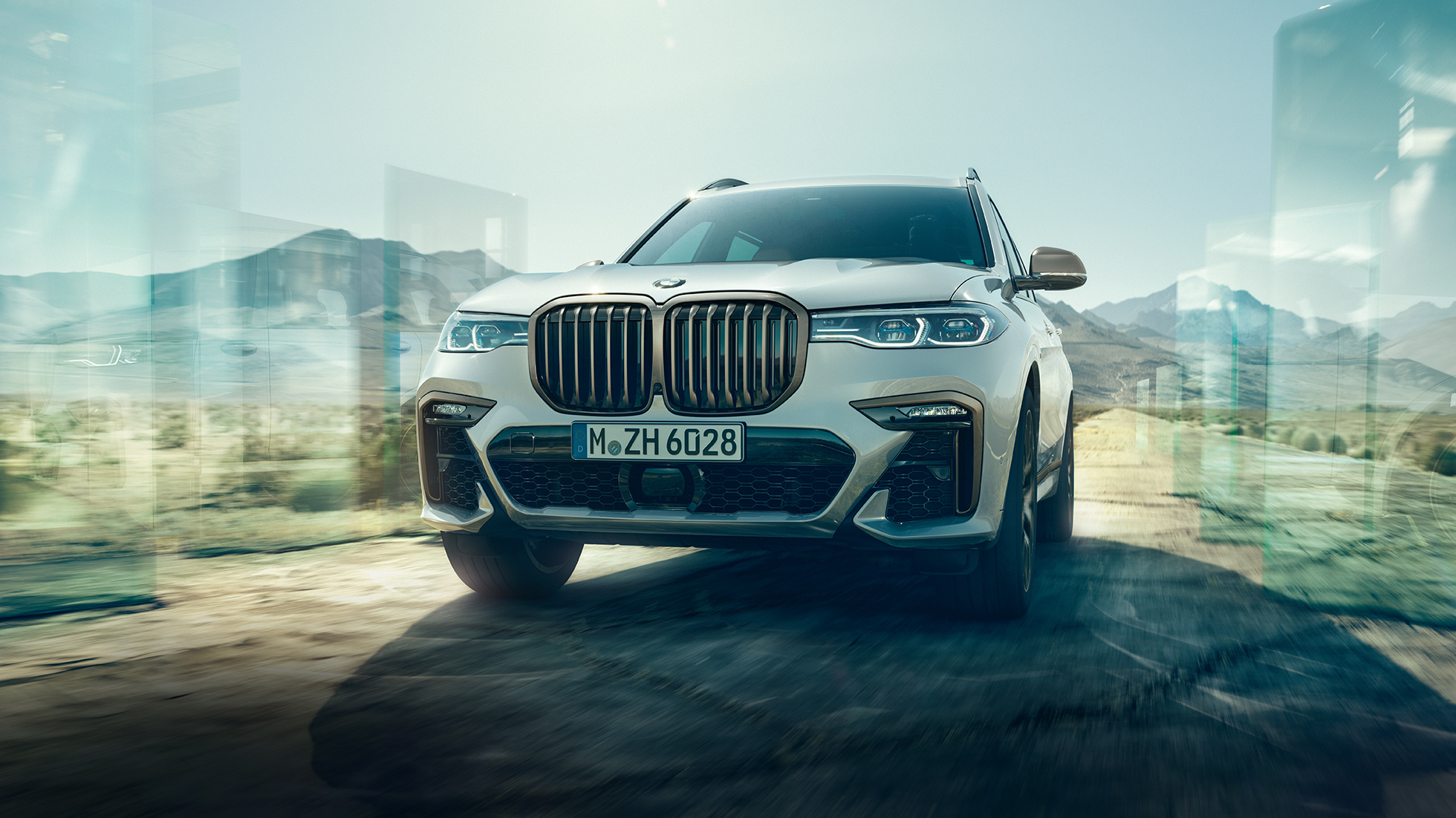 BMW X7 M50d, schuin onderaanzicht BMW X7 M50d: schuin onderaanzicht van rijdende, witte BMW X7
