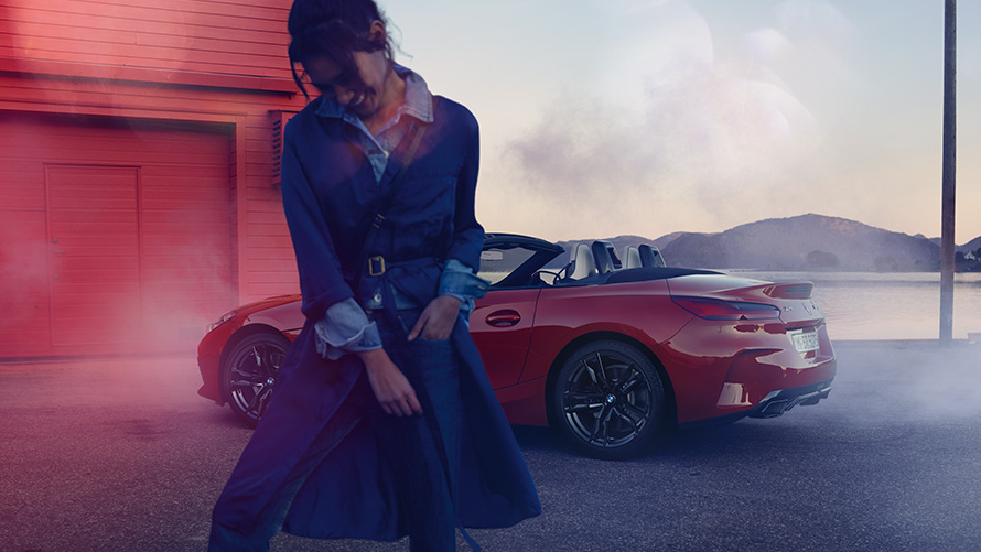 BMW Z4 M40i Roadster G29 met geopende cabriokap BMW Z4 M40i Roadster G29 driekwart achteraanzicht met open cabriokap en vrouw op voorgrond