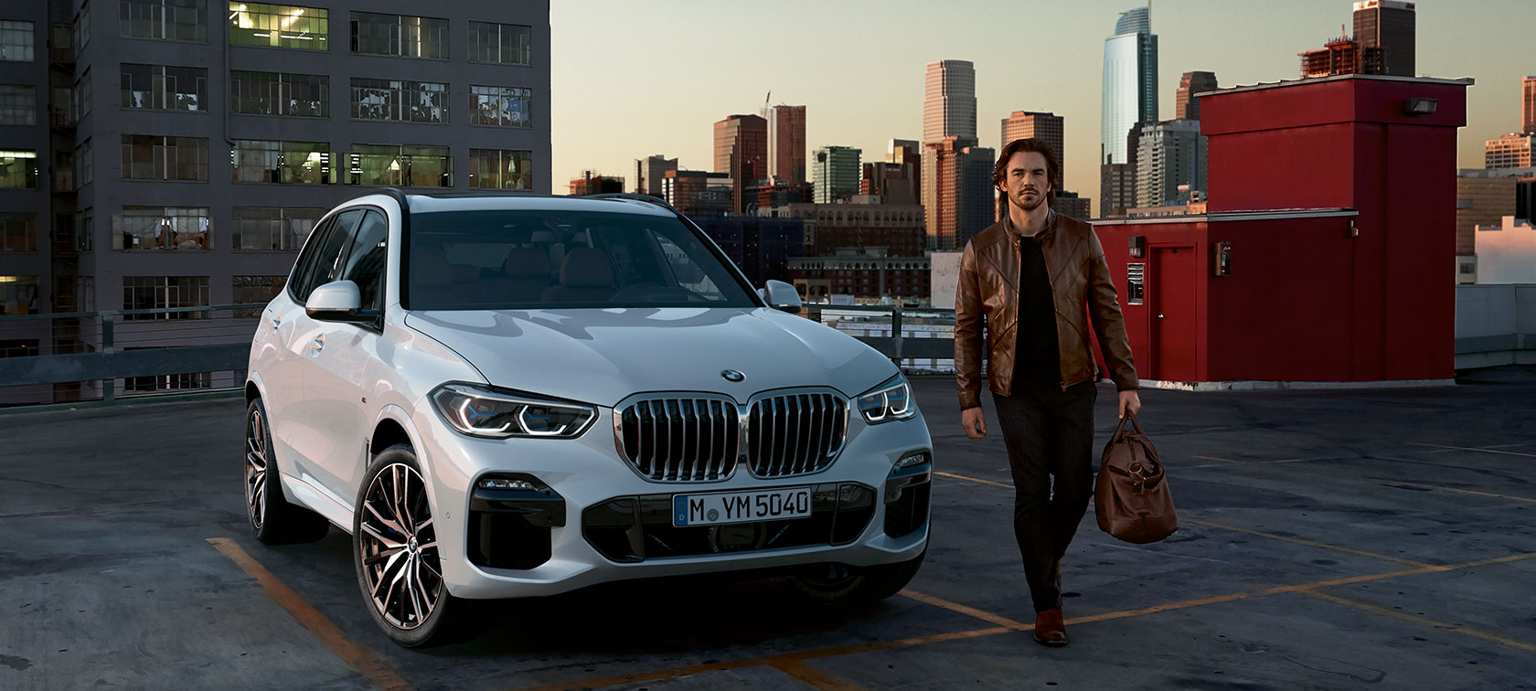 Man in leren jack draagt de 48h Hour-tas van de BMW Lifestyle X Edition. Man in leren jack draagt de 48h Hour-tas van de BMW Lifestyle X Edition.