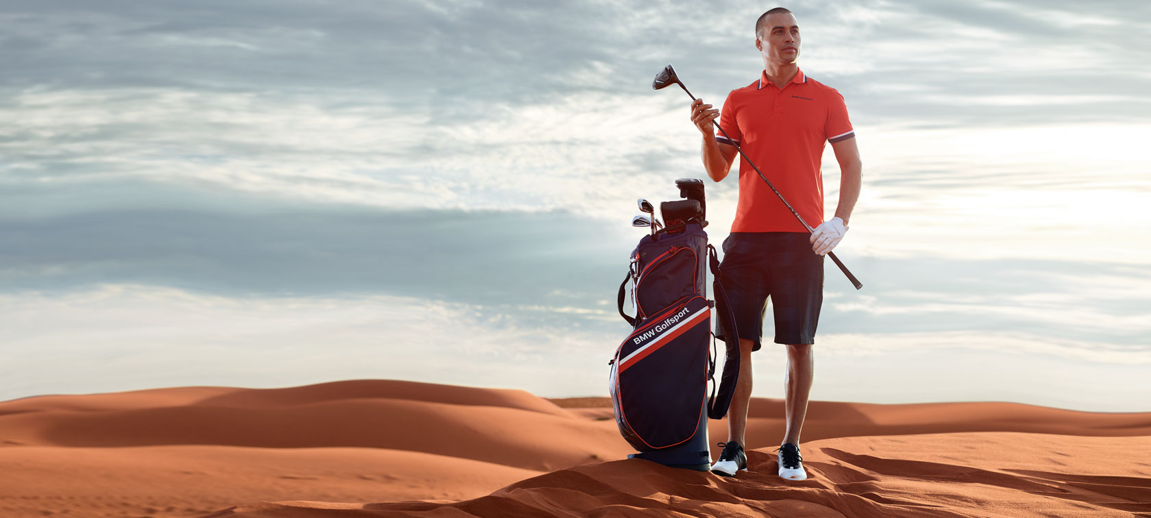 Man in poloshirt met BMW Golfsport Cartbag. Man in poloshirt met BMW Golfsport Cartbag.
