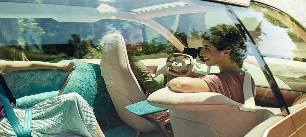 Interieur van de BMW Vision iNEXT Interieur van de BMW Vision iNEXT met vrouw voorin die zich naar de passagier achterin omdraait