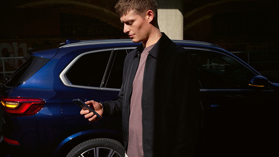 BMW Digital Key – tot vijf gebruikers installeren BMW Digital Key installeren met tot aan vijf gebruikers man met smartphone voor BMW X5.