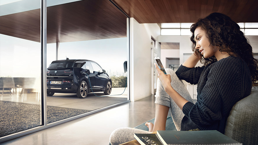 Digital Charging Service Woman using feature “Digital Charging Service“ at home on smartphone for her BMW i3