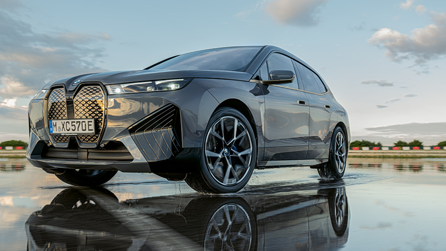 BMW wielen, driekwart vooraanzicht BMW iX (i20) op nat wegdek BMW wielen, driekwart vooraanzicht BMW iX (i20) op nat wegdek