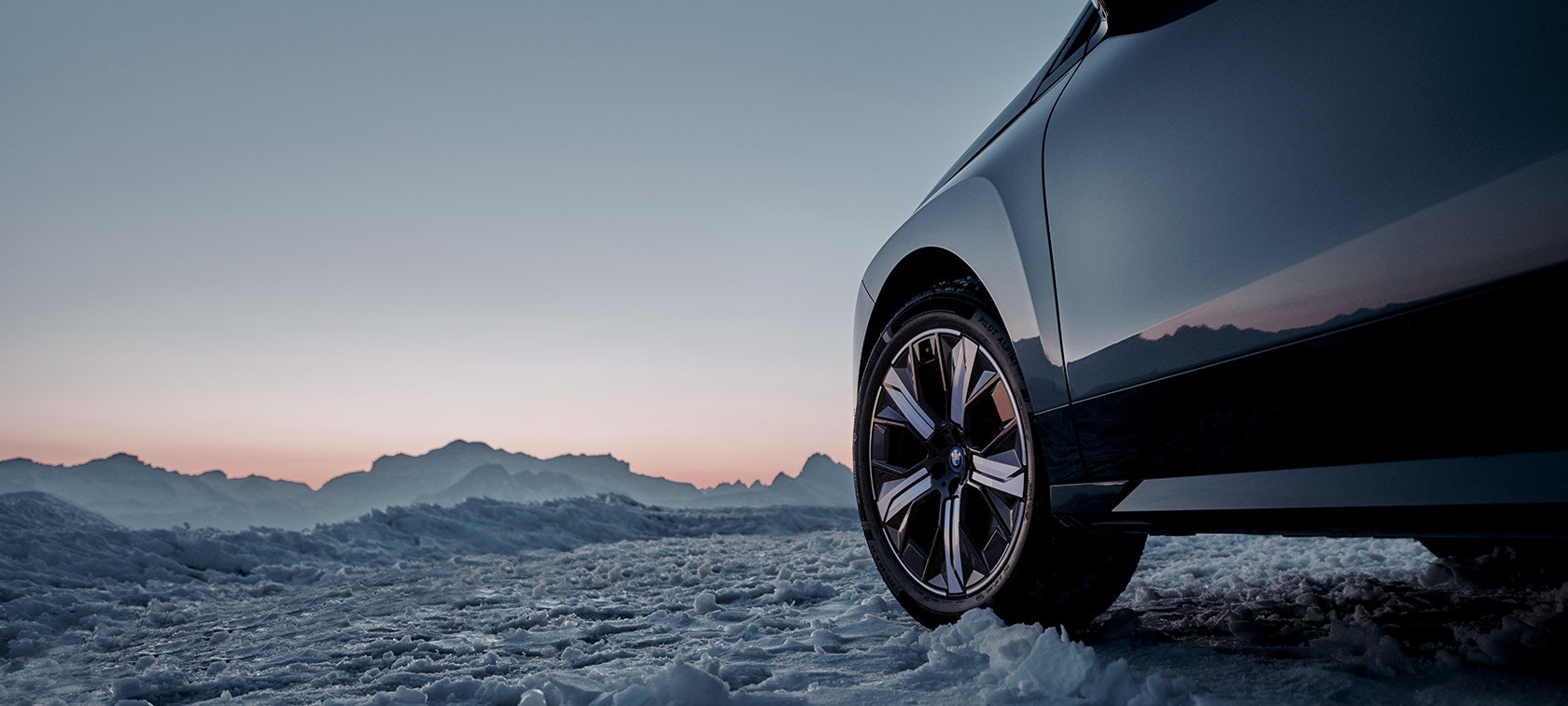 Originele BMW wielen op BMW iX (I20) in sneeuw voor bergen Originele BMW wielen op BMW iX (I20) in sneeuw voor bergen