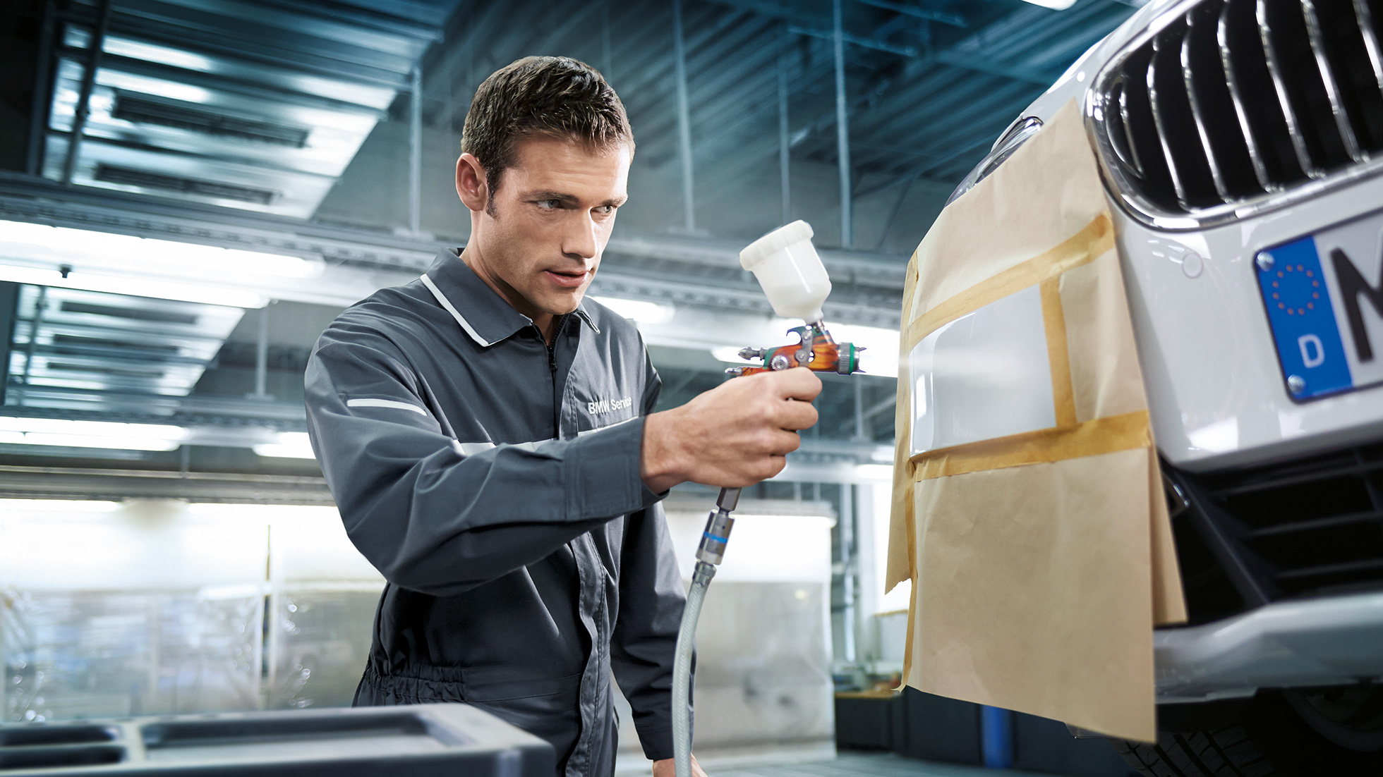 BMW reparatie uitdeukservice We zien een monteur die een BMW spuit