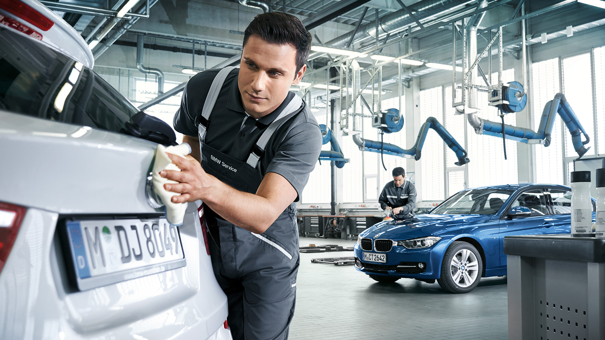 BMW reparatieservice lekherstel We zien een monteur die een BMW schoonveegt
